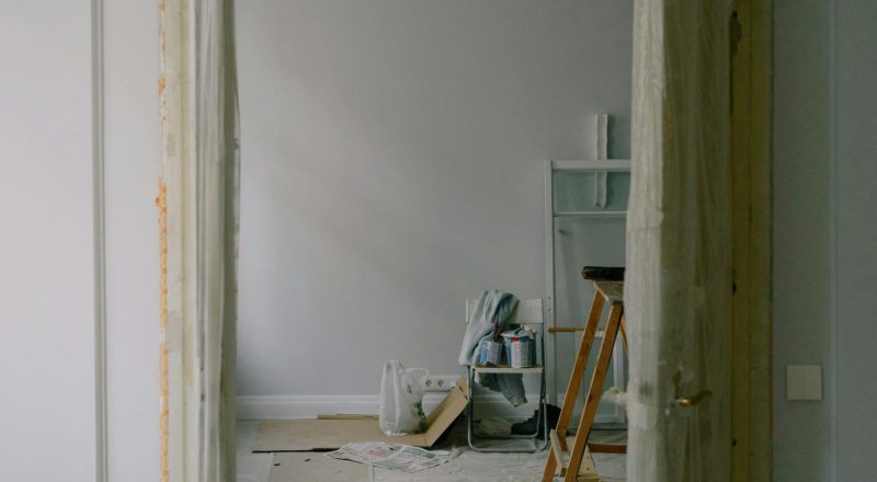 pexels-photo-5691545-5691545 View through an open doorway into a room undergoing renovation with tools and materials scattered.